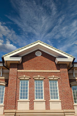 High windows on a brick building under blue skies