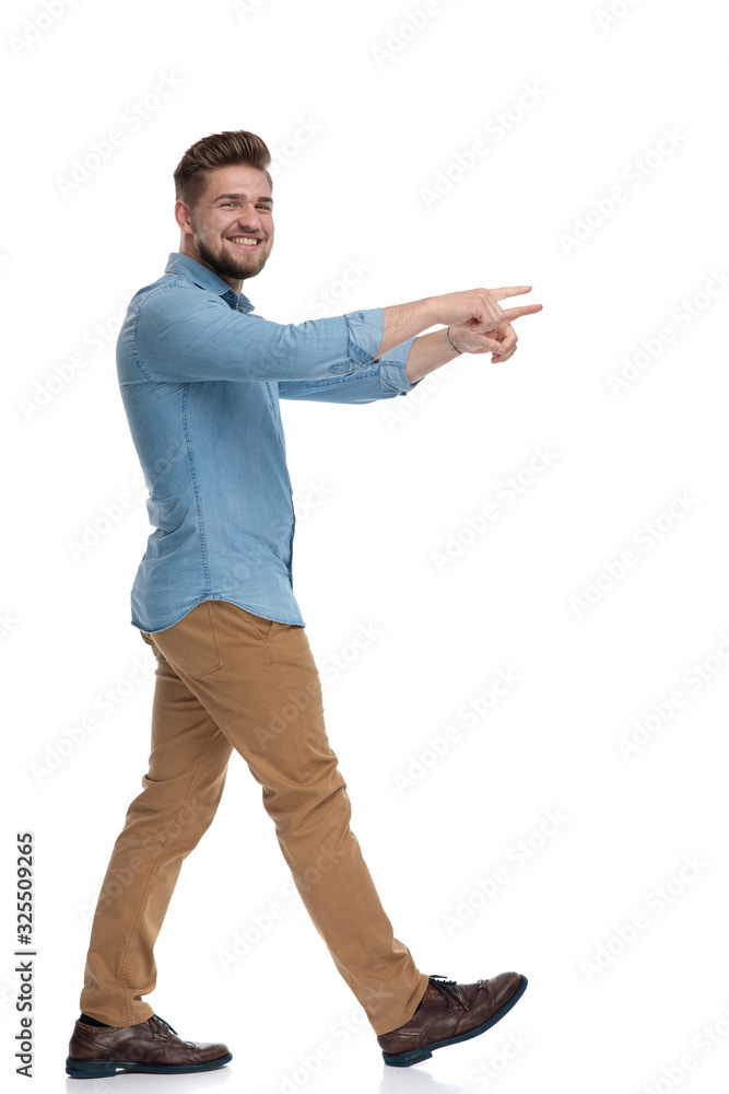 Canvas Prints Side view of a cheerful casual man pointing