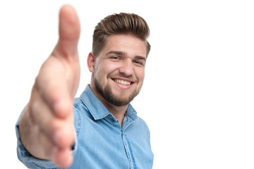 Cheerful casual man smiling and reaching for a handshake