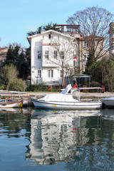 Fototapeta na wymiar White old mansion and boat at the sea