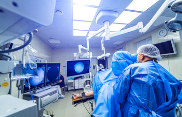 Medical team performing surgical operation in bright modern surgery room. Operating theatre. Modern...