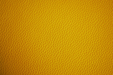 Leather texture close up. Yellow fashionable background, top view. Stylish wallpaper of golden color. Rough surface.	