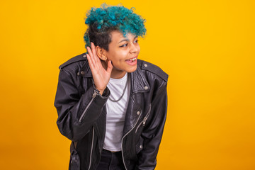 young modern brunette girl with curly blue hair of afro american ethnicity isolated on color background