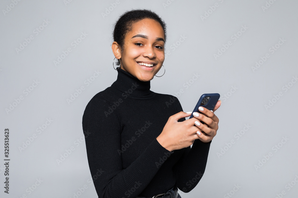 Wall mural young latin woman read something on cellphone isolated on gray background