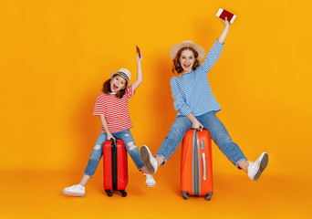 happy journey! family of travelers mother and child  with suitcases tickets and passports on yellow background.