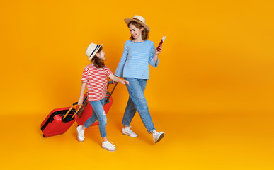 happy journey! family of travelers mother and child  with suitcases tickets and passports on yellow background.