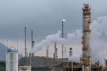 Landscape of a refinery, with refining towers and smoking chimneys