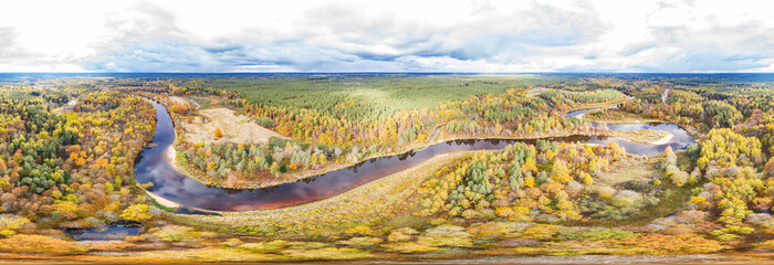 Forest in autumn colors. Colored trees and a meandering blue river. Red, yellow, orange, green...