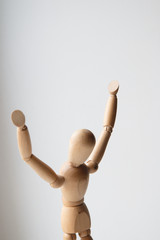 Wooden man figure praying with hands up.