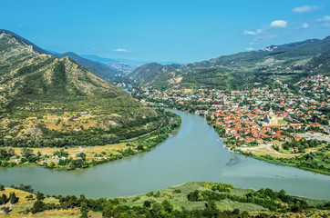 Fototapeta na wymiar View from Jarvi Monastery down on Mtskheta - the old capital of Georgia - the River Kora converges with the River Araguae flowing down from the Caucasus mountains to the north