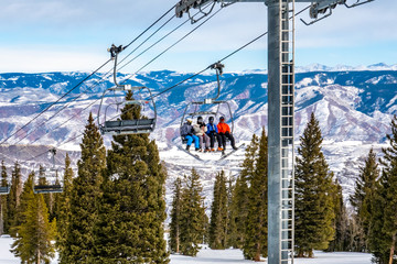 Skiers and snowboarders ascend the Alpine Springs chairlift at the Aspen Snowmass ski resort, in...