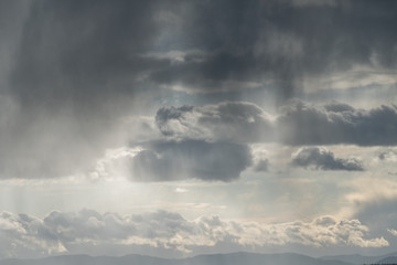 cloudy sky with sun light shine through the gaps near sunset