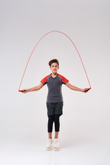 This is how I jump. Full-length shot of a teenage boy engaged in fitness, skipping using jump rope. Isolated on white background. Sport, training, fitness, active lifestyle concept