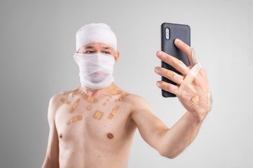 Picture of sufferer male with bandaged head do selfie