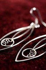 Fototapeta na wymiar Earrings made of silver with an elliptical design and a circle in the central part, placed on velvet fabric