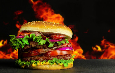 Delicious tasty home made hamburger with meat and cheese and black textured background. Concept fast food.