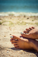 Woman tanned legs on sand beach. Travel concept. Happy feet in tropical paradise