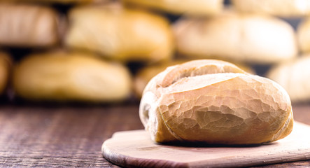 traditional Brazilian bread, called French bread, with an unfocused bakery background. National day of Brazilian French bread.