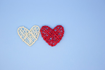 White and red wooden heart on a blue background. Pattern hearts top view. Valentine's day greeting card. Love concept. Place for text