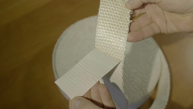Men's hands hold a skewed non-flammable fabric