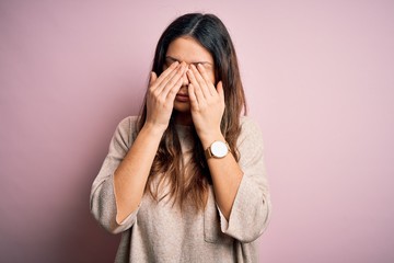 Young beautiful brunette woman wearing casual sweater standing over pink background rubbing eyes for fatigue and headache, sleepy and tired expression. Vision problem