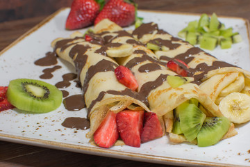 Healthy crepes with fruits, banana, kiwi and strawberry. Healthy french breakfast