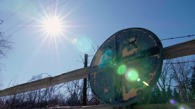 Abandoned Railroad Crossing Sign Time-Lapse Of Moving Sun with flares