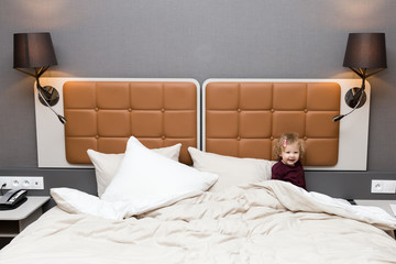 petite fille joue dans un grand lit