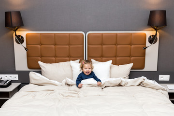 petite fille joue dans un grand lit