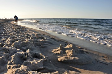 Zamek na piasku i ludzie idący plażą, Jurata, Polska