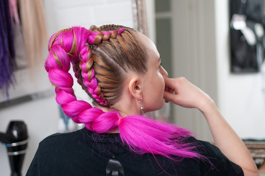 Pink braids on a woman in profile