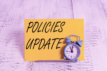 Writing note showing Policies Update. Business concept for act of adding new information or...
