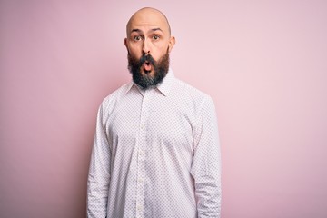 Handsome bald man with beard wearing elegant shirt over isolated pink background afraid and shocked with surprise expression, fear and excited face.