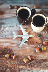 Cup of coffee with the airplane on the wood background. Traveling concept