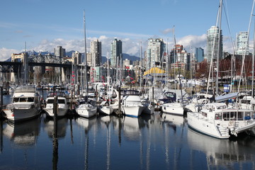 Fototapeta na wymiar Boat harbour in front of the Burrard Bridge in Vancouver, British Columbia, Canada. It spans False Creek and connects the Kitsilano and West-End neighbourhoods of Vancouver.