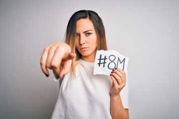 Beautiful woman with blue eyes celebrating 8th march womens day over white background pointing with finger to the camera and to you, hand sign, positive and confident gesture from the front