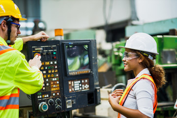 The engineering team looks stern about the machine settings in the factory. Maintenance engineers about the monitoring protection data on the tablet computer.
