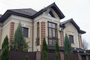 one large brown private house with windows under a tiled roof 