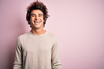Young handsome man wearing casual t-shirt standing over isolated pink background with a happy and...