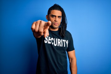 Young african american afro safeguard man with dreadlocks wearing security uniform pointing with...