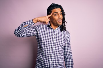 Young handsome african american afro man with dreadlocks wearing casual shirt Smiling pointing to head with one finger, great idea or thought, good memory