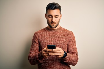 Young handsome man having conversation using smartphone over white background with a confident expression on smart face thinking serious