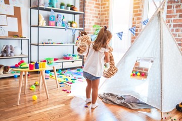 Young beautiful blonde girl kid enjoying play school with toys at kindergarten, smiling happy playing at home