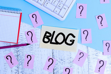 Conceptual hand writing showing Blogquestion. Concept meaning regularly updated website web page run by individual Writing tools and scribbled paper on top of the wooden table