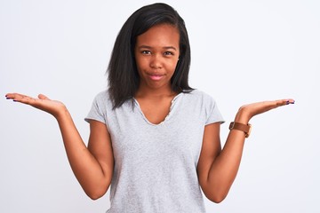 Beautiful young african american woman wearing casual t-shirt over isolated background clueless and...
