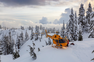 North Vancouver, British Columbia, Canada. North Shore Search and Rescue are rescuing a man skier in the backcountry of Seymour Mountain with a helicopter in winter during sunset.