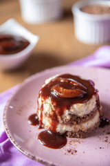 Grießflammerie aus Grieß mit Kakao und Sahne mit gekochtem Pflaumenmus und Pflaumen auf rosa ovalem Teller und Holz