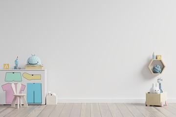 Mock up in children's playroom with cabinet and table sitting doll on empty white wall background.