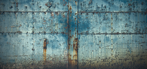 スタッドのある古びた青い門扉のテクスチャー
