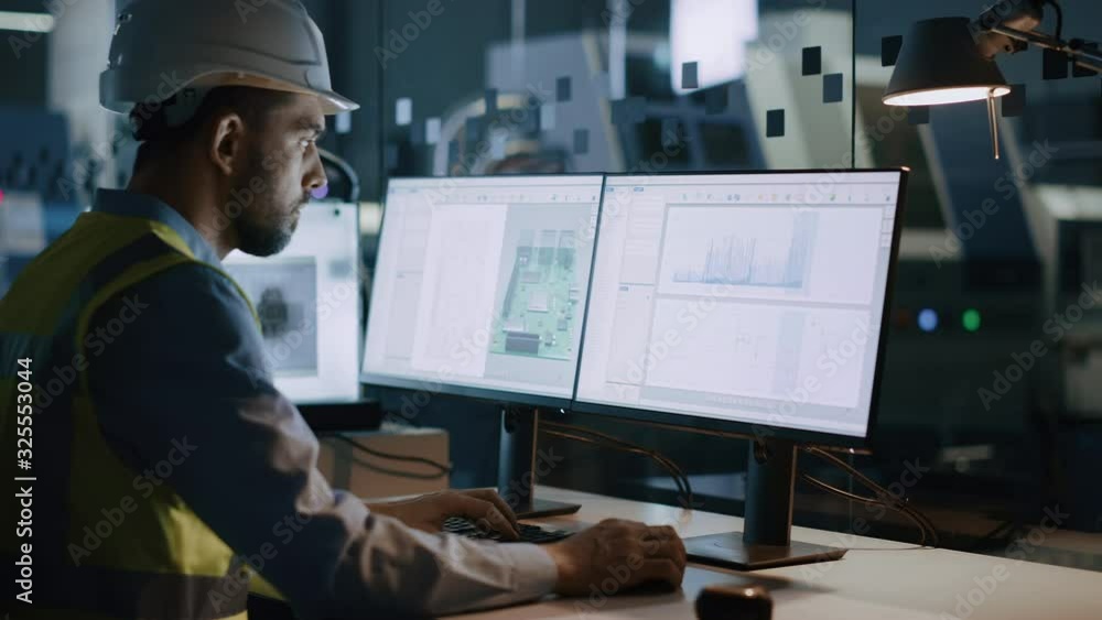 Poster electronics design factory: portrait of handsome male engineer wearing safety vest working on comput